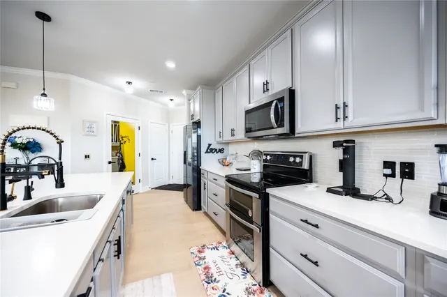 a kitchen with kitchen island granite countertop a sink stainless steel appliances and cabinets