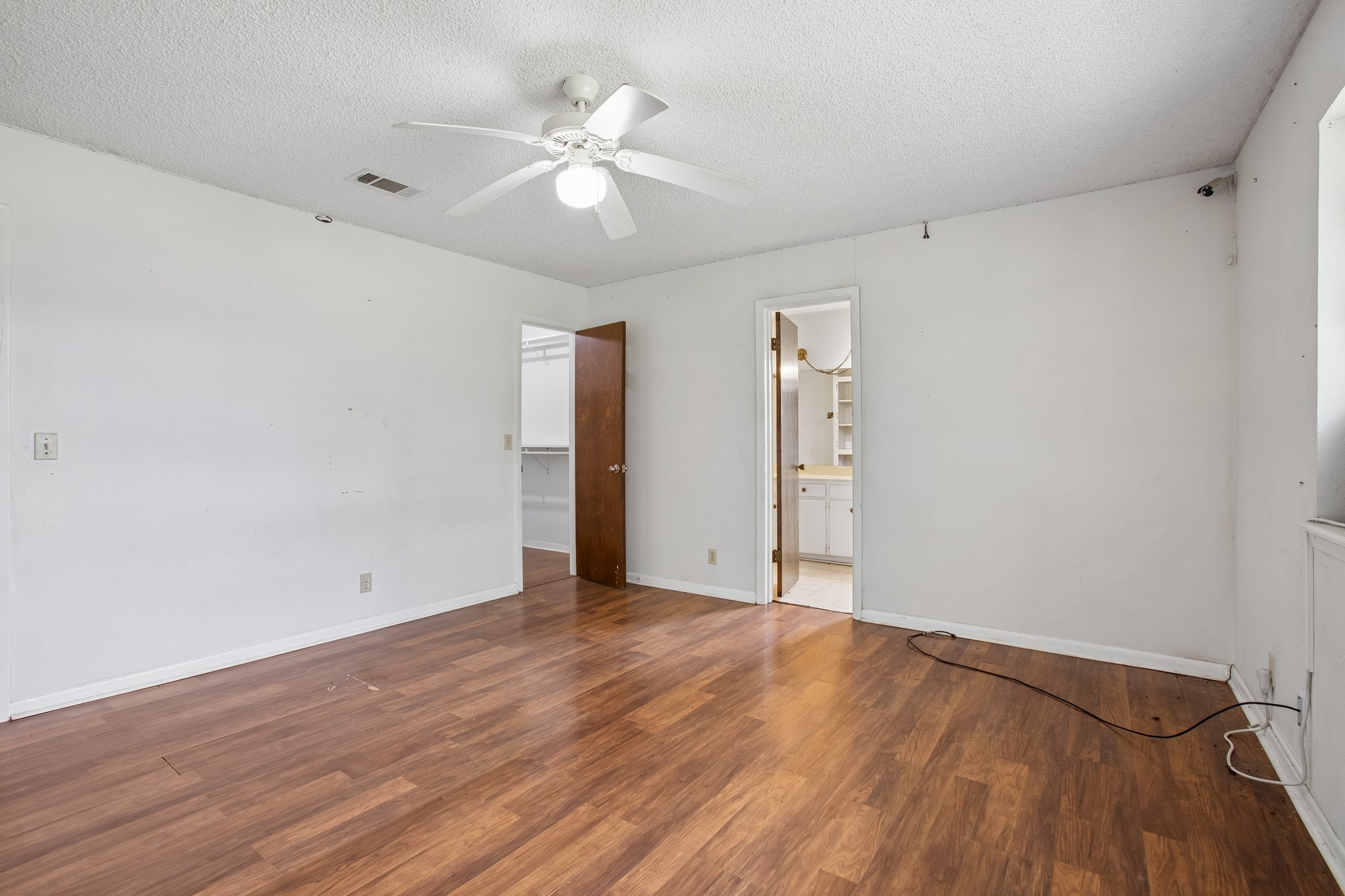 406 Monkey Road Elgin, TX 78621 - Photo 15 of 39 Spacious room featuring wood-finish flooring, a ceiling fan with integrated lighting, and white walls