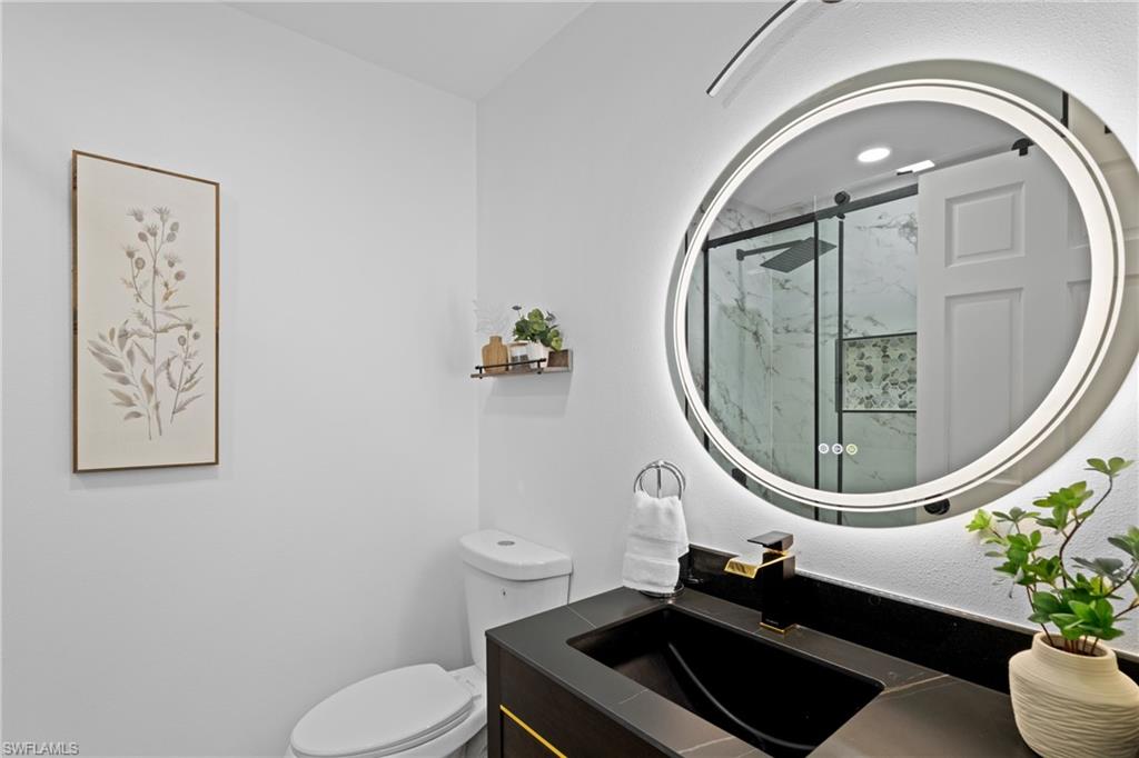 731 102nd Avenue North Naples, FL 34108 - Photo 12 of 23 a bathroom with a toilet a sink and mirror