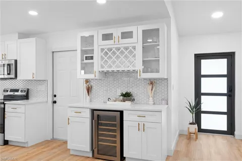 a kitchen with white cabinets and window