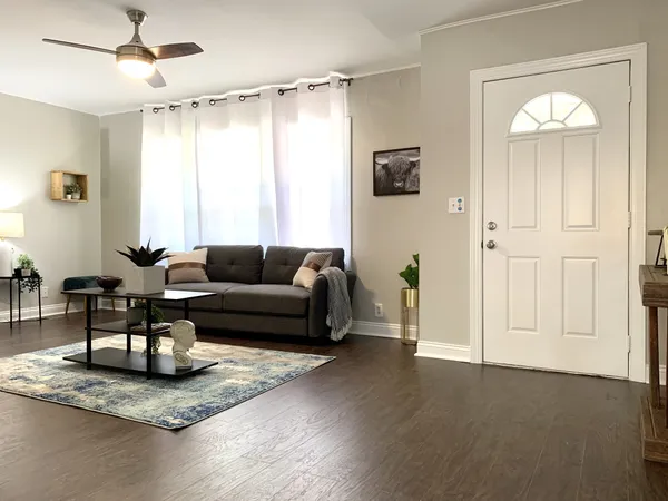 a living room with furniture and a wooden floor