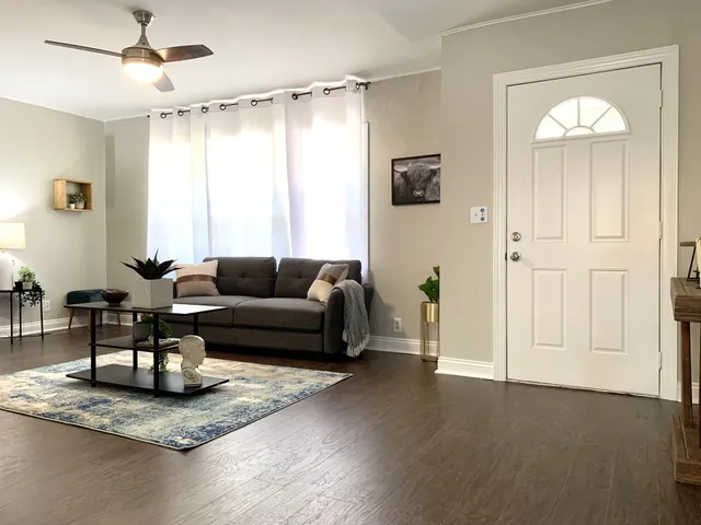 a living room with furniture and a wooden floor