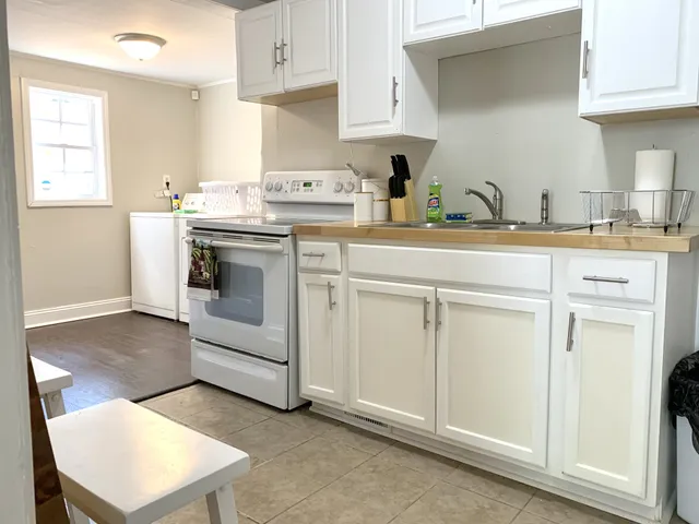 a kitchen with white cabinets and white appliances