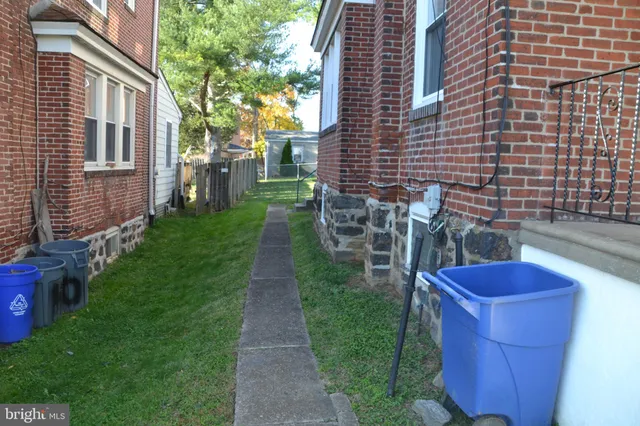 a view of a backyard with table and chairs potted plants and a house