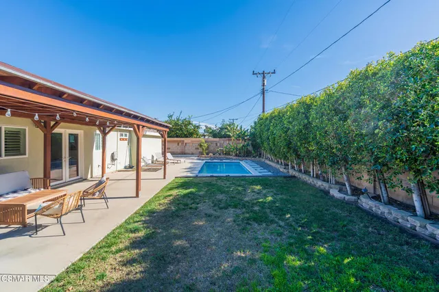 a view of a house with backyard sitting area and garden