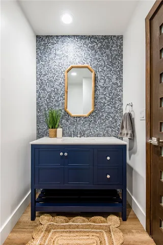 a bathroom with a granite countertop bathtub shower sink vanity and toilet