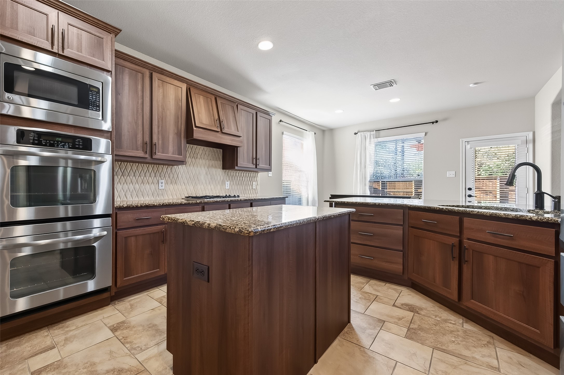 22 North Arrow Canyon Circle Spring, TX 77389 - Photo 9 of 50 a kitchen with stainless steel appliances granite countertop a stove microwave and sink