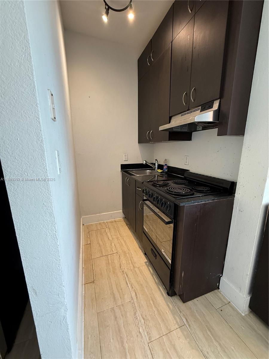 1330 Pennsylvania Avenue, Unit 206 Miami Beach, FL 33139 - Photo 11 of 14 a kitchen with granite countertop a stove and a sink