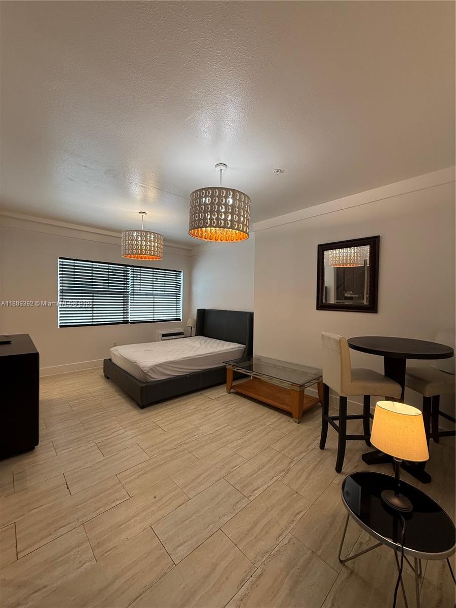 1330 Pennsylvania Avenue, Unit 206 Miami Beach, FL 33139 - Photo 14 of 14 a bedroom with a bed a table and chair