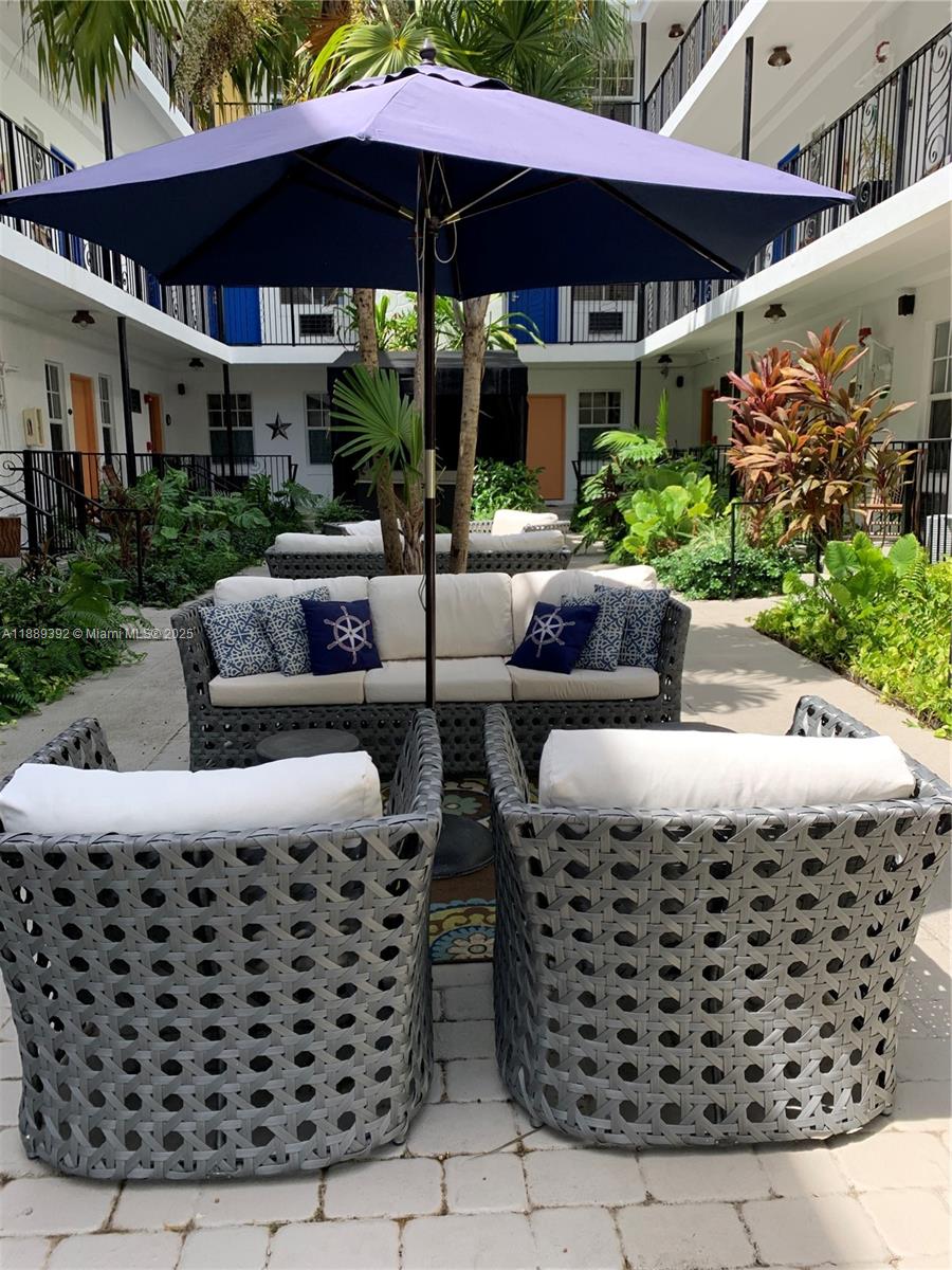 1330 Pennsylvania Avenue, Unit 206 Miami Beach, FL 33139 - Photo 3 of 14 a patio with a table and chairs under an umbrella