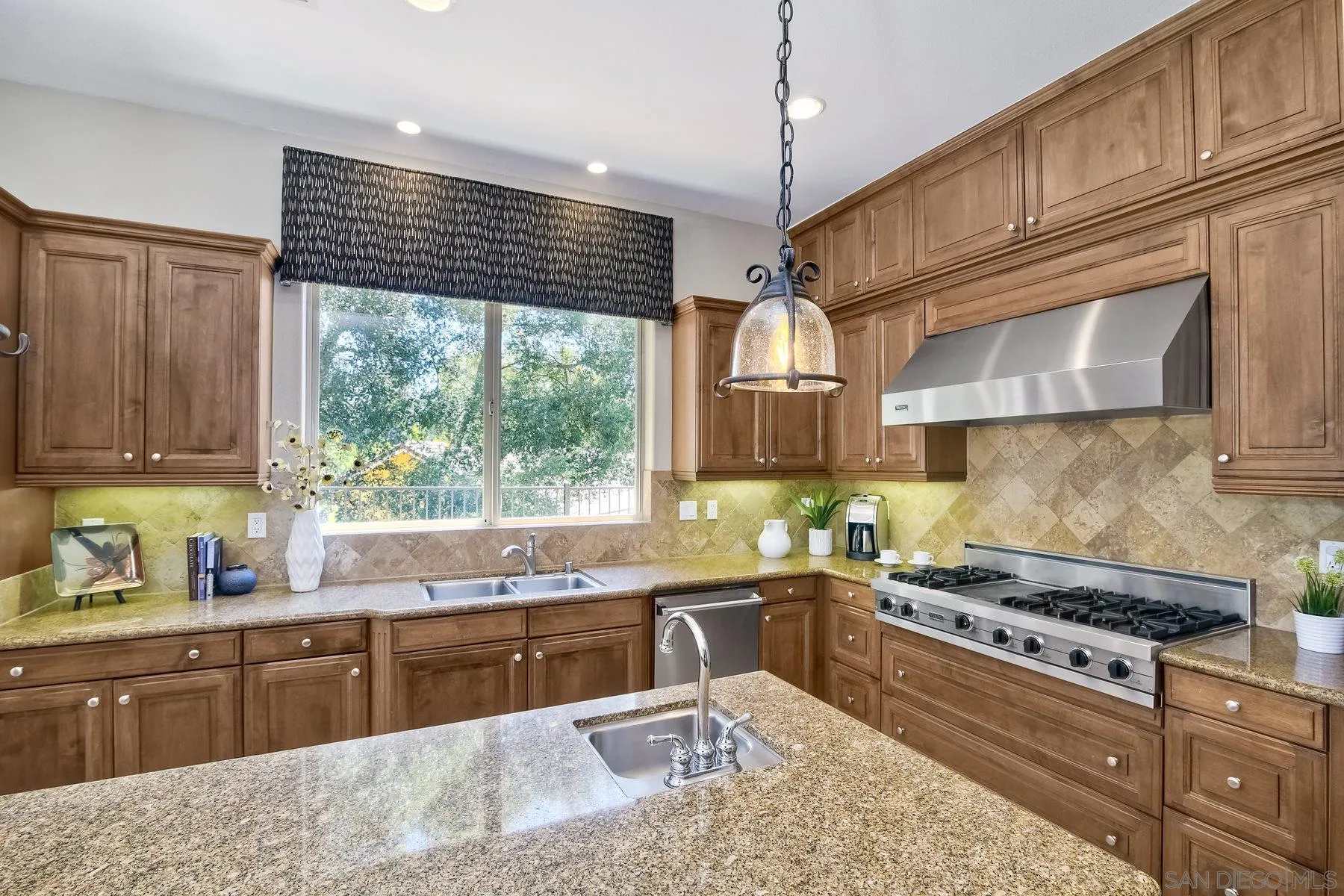 14050 Lake Poway Road Poway, CA 92064 - Photo 11 of 29 a kitchen with kitchen island granite countertop wooden cabinets a stove a sink and a large window