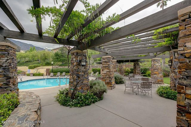 a view of a patio with table and chairs potted plants and large tree