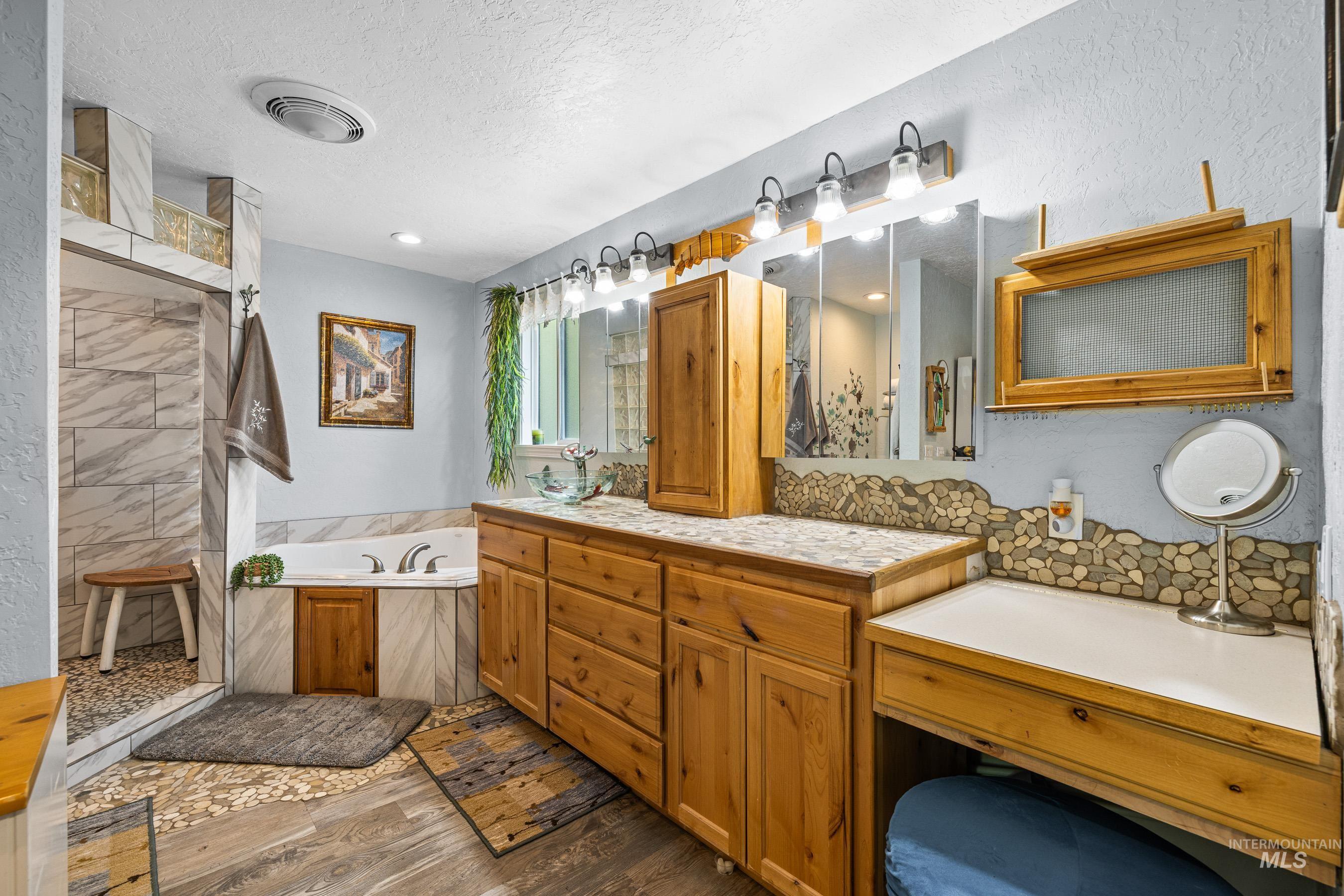 192 East Shingle Creek Road Riggins, ID 83549 - Photo 27 of 50 Full bath featuring a bath, double vanity, a textured ceiling, dark wood-style flooring, and tiled shower