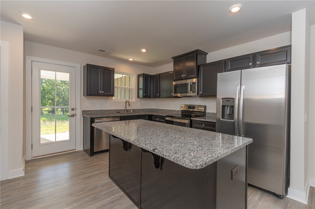 233 Scenic Road Anderson, SC 29621 - Photo 12 of 50 A well-appointed kitchen features dark cabinetry, ample counter space, and modern stainless steel appliances.