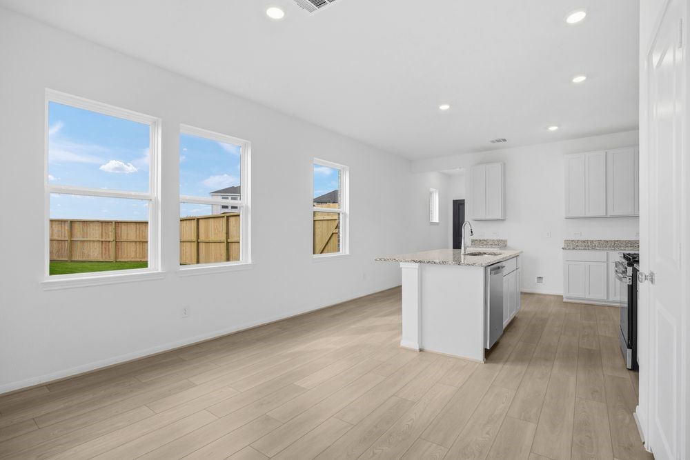 735 Willow Grove Lane Rosenberg, TX 77471 - Photo 5 of 26 a view of a kitchen with a sink wooden cabinets and a window