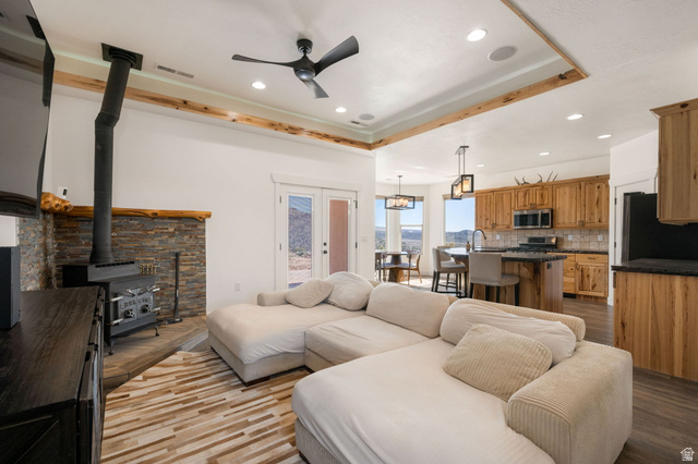 62 North Lucky 7 Road Veyo, UT 84782 - Photo 6 of 43 Living area with a raised ceiling, wood finished floors, a ceiling fan, a wood stove, and recessed lighting