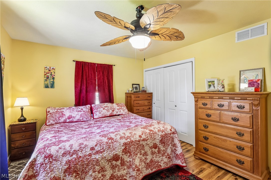 6109 North Oval Road Clinton, OH 44216 - Photo 21 of 47 Primary bedroom with ceiling fan / light, double closet and wood flooring