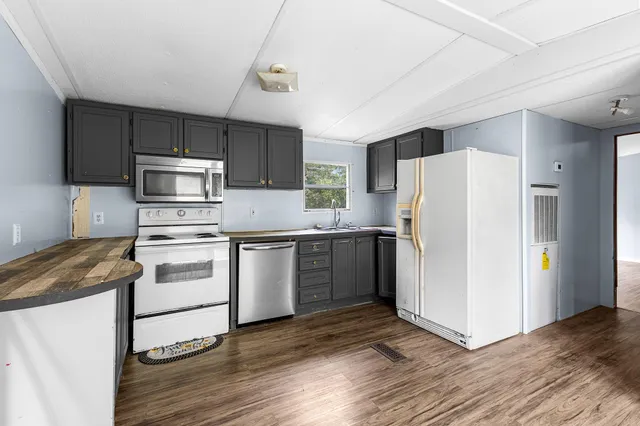 a kitchen with a refrigerator cabinets and wooden floor