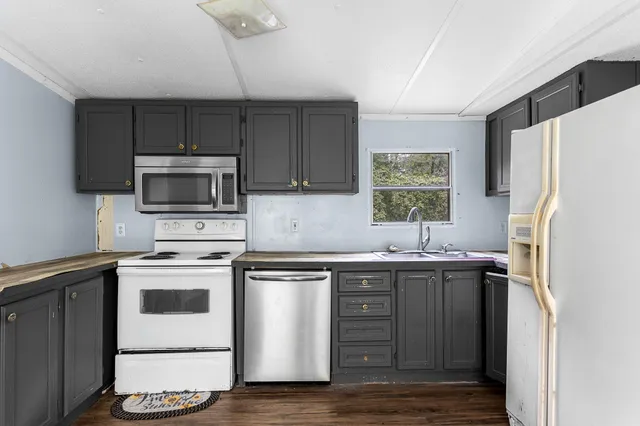 a kitchen with a sink a microwave a refrigerator and cabinets