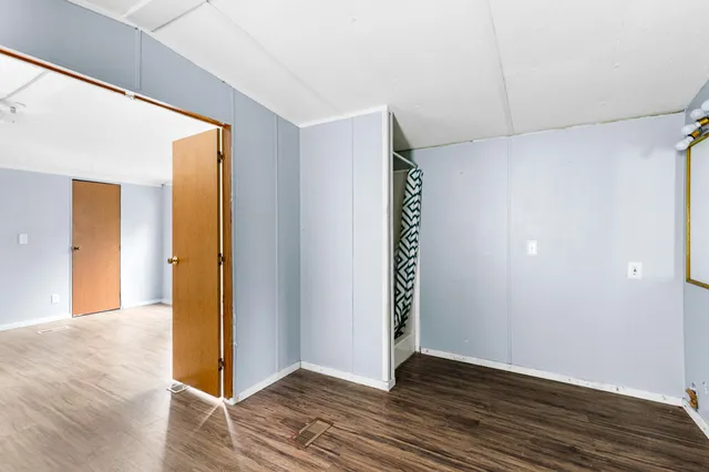 a view of an empty room with wooden floor