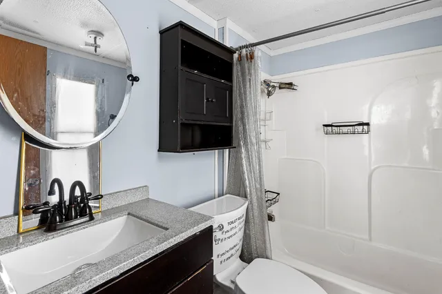 a bathroom with a granite countertop sink toilet and shower