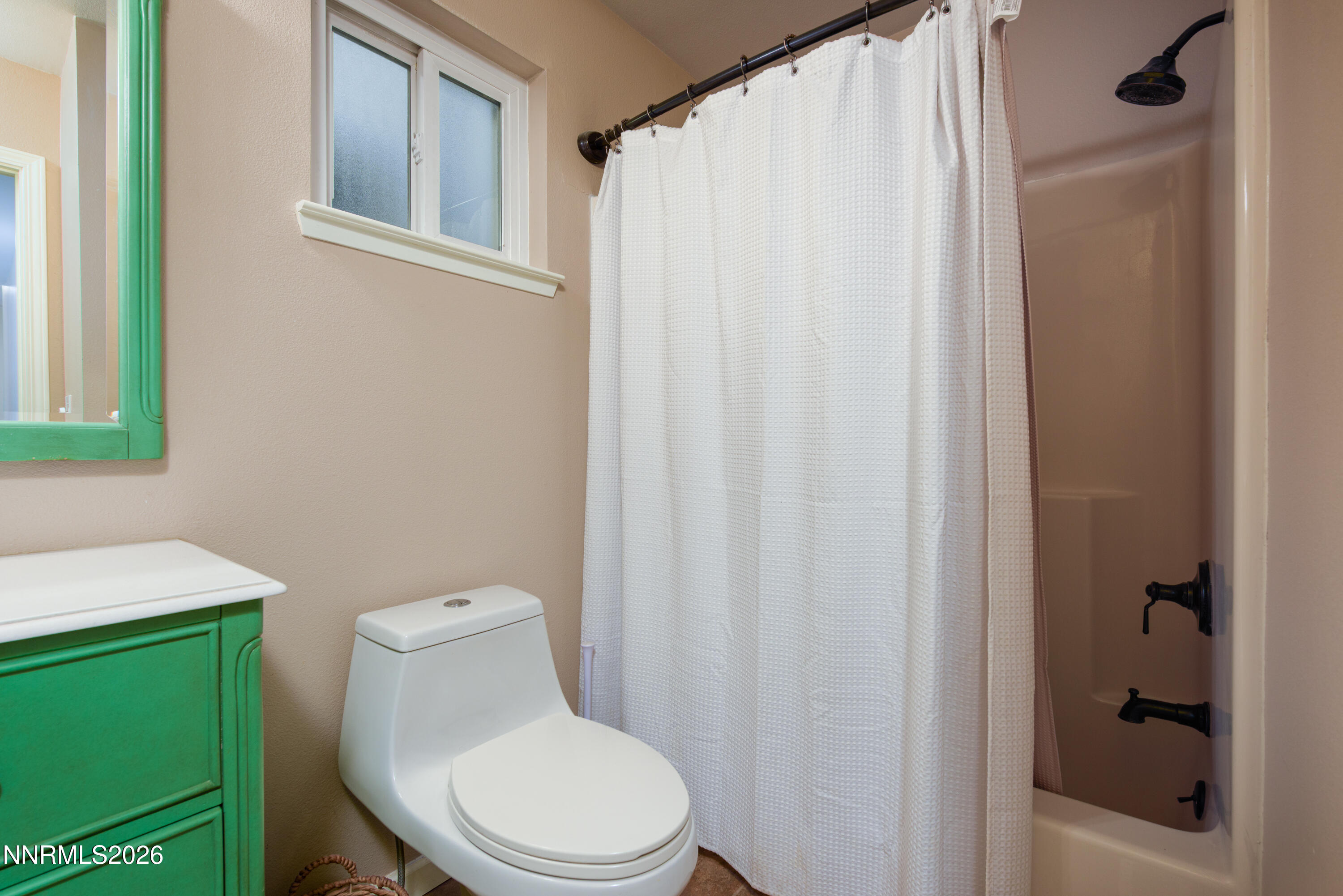 624 Victoria Way Gardnerville, NV 89460 - Photo 14 of 25 a white toilet sitting next to a shower curtain