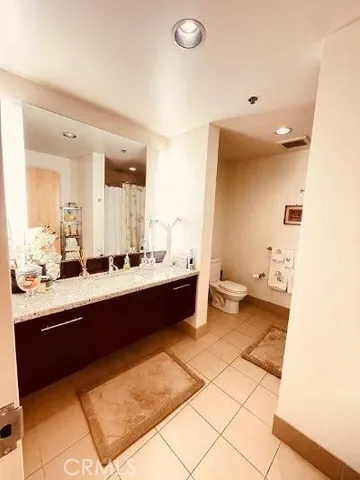 a large bathroom with a double vanity sink toilet and a mirror