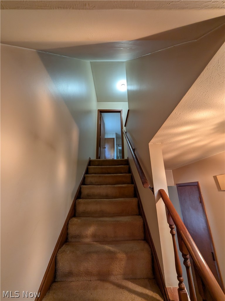 1161 Gulf Road Elyria, OH 44035 - Photo 16 of 34 Carpeted staircase with wooden handrail and balusters