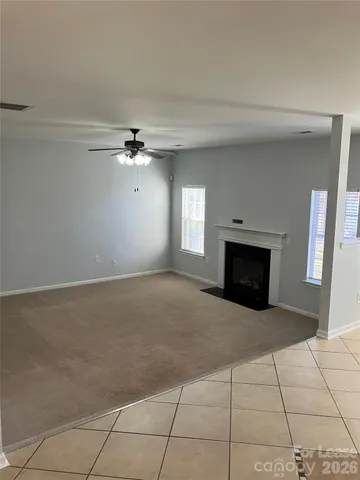 a view of an empty room with a fireplace and a window