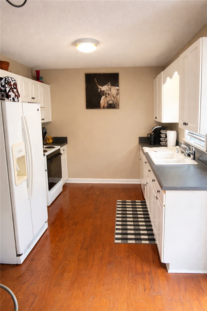736 Rodgers Road Seneca, SC 29678 - Photo 5 of 7 This bright kitchen features wood flooring and white cabinetry, ready for your culinary adventures.