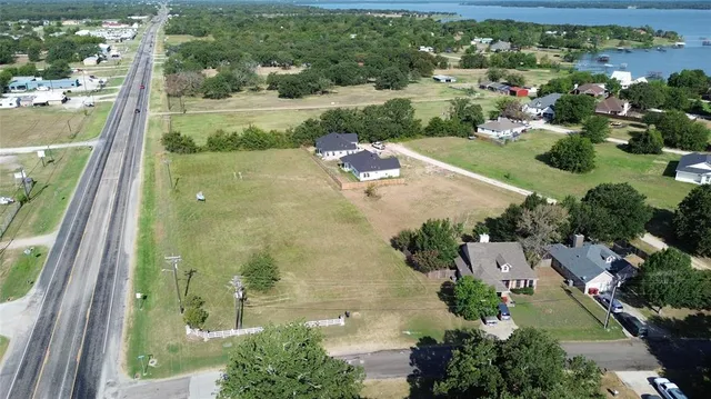 an aerial view of residential houses with outdoor space and street view