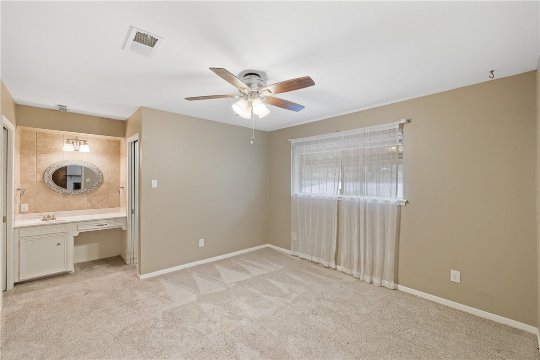 29 Dogwood Road Huntsville, TX 77320 - Photo 17 of 39 Unfurnished bedroom with light carpet, ceiling fan, and an office area