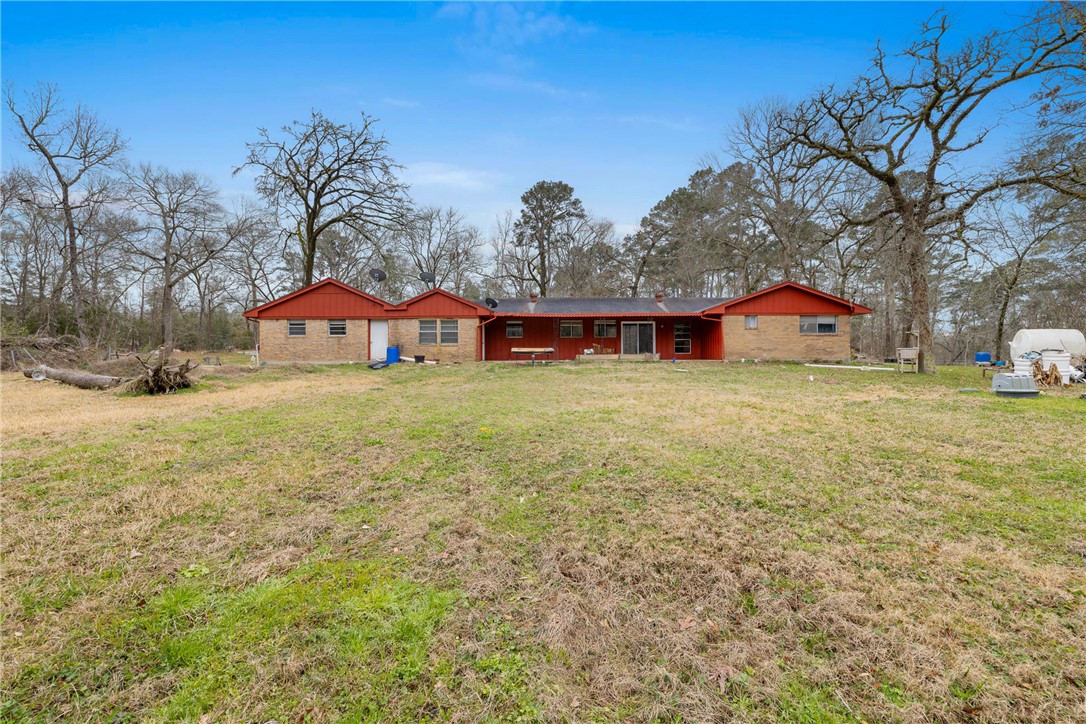 29 Dogwood Road Huntsville, TX 77320 - Photo 4 of 39 Back of house featuring a lawn
