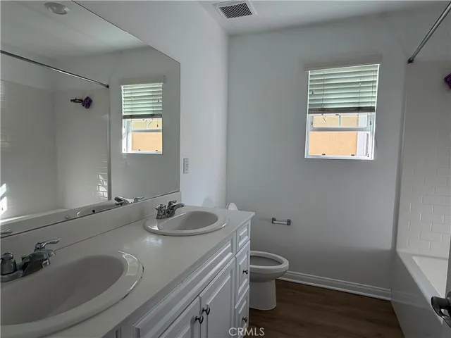 a bathroom with a sink toilet and window