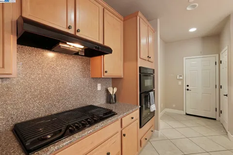 a kitchen with stainless steel appliances granite countertop a sink and a refrigerator