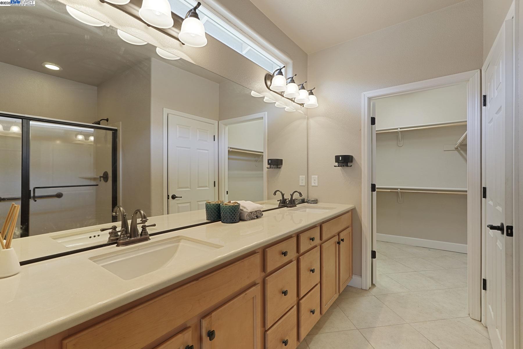 2961 Clear Pt Way Manteca, CA 95336 - Photo 30 of 54 a bathroom with a double vanity sink a mirror and shower