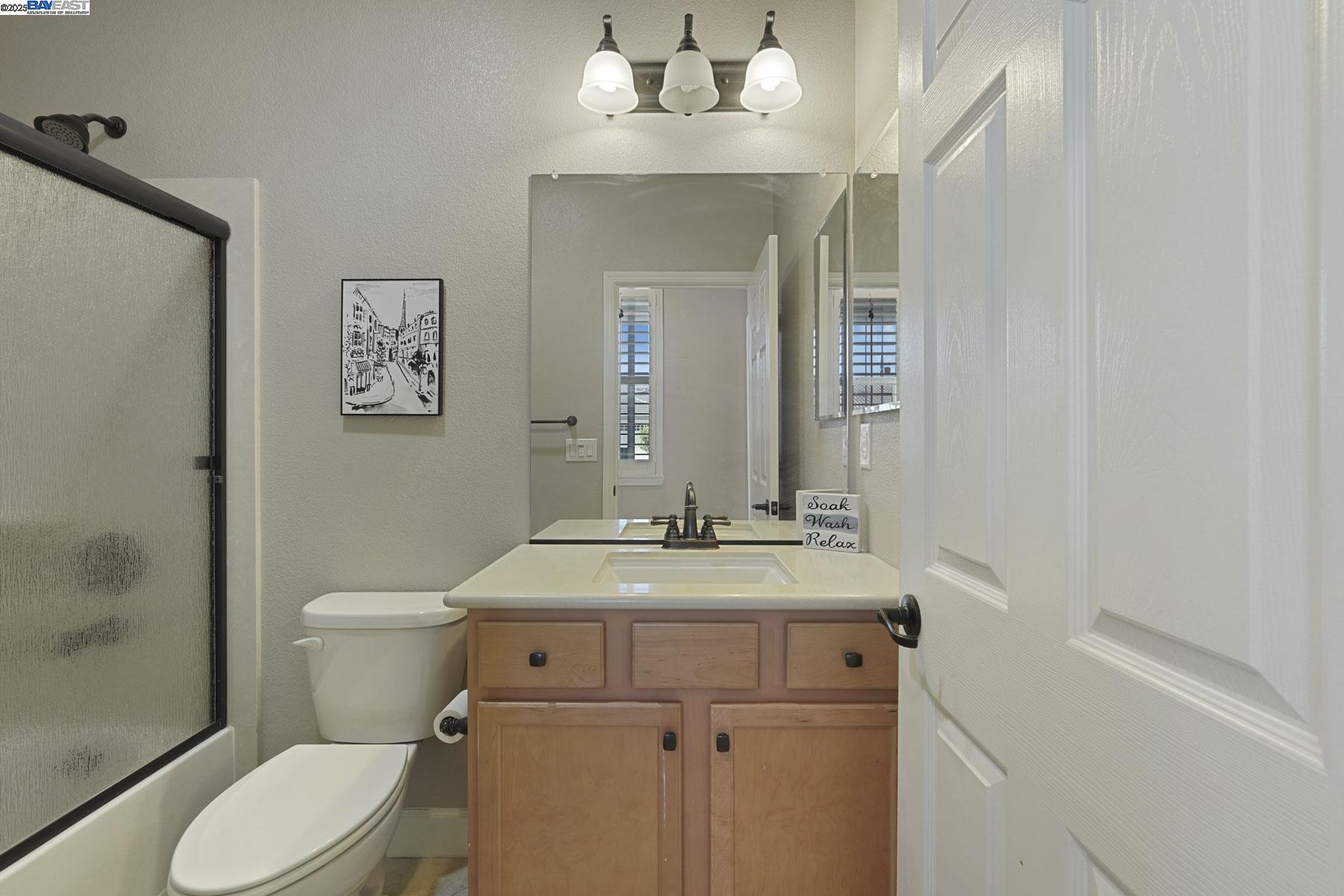 2961 Clear Pt Way Manteca, CA 95336 - Photo 33 of 54 a bathroom with a sink vanity mirror and toilet