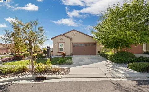a front view of a house with a yard and a garden