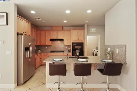 a kitchen with granite countertop a sink stainless steel appliances and cabinets