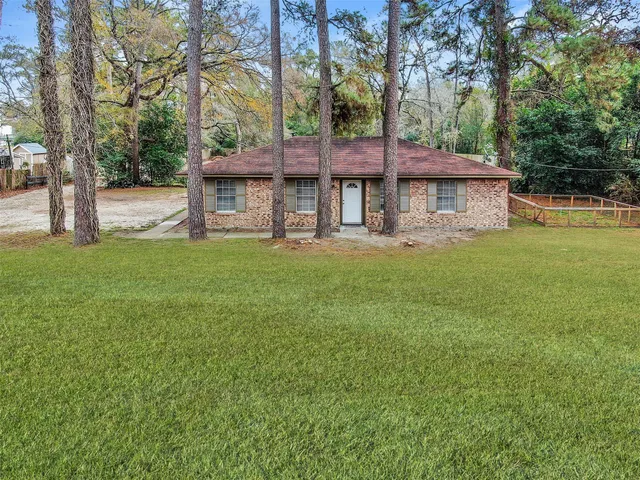 a view of a big house with a big yard and large trees