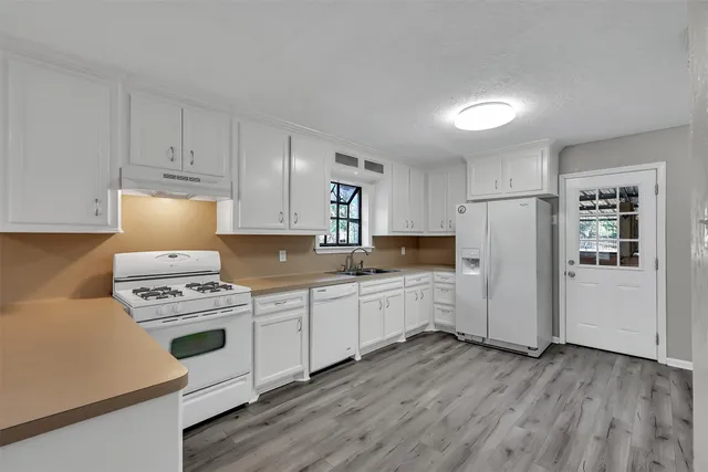 a kitchen with white cabinets and white appliances