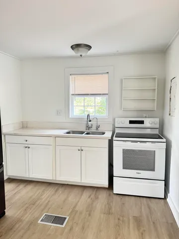 a kitchen with granite countertop white cabinets and white appliances