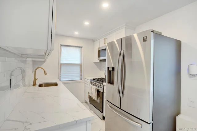 a kitchen with granite countertop white cabinets and sink