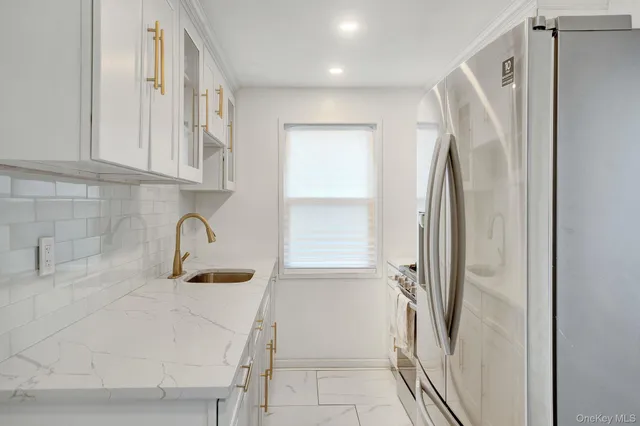 a kitchen with stainless steel appliances a refrigerator sink and stove