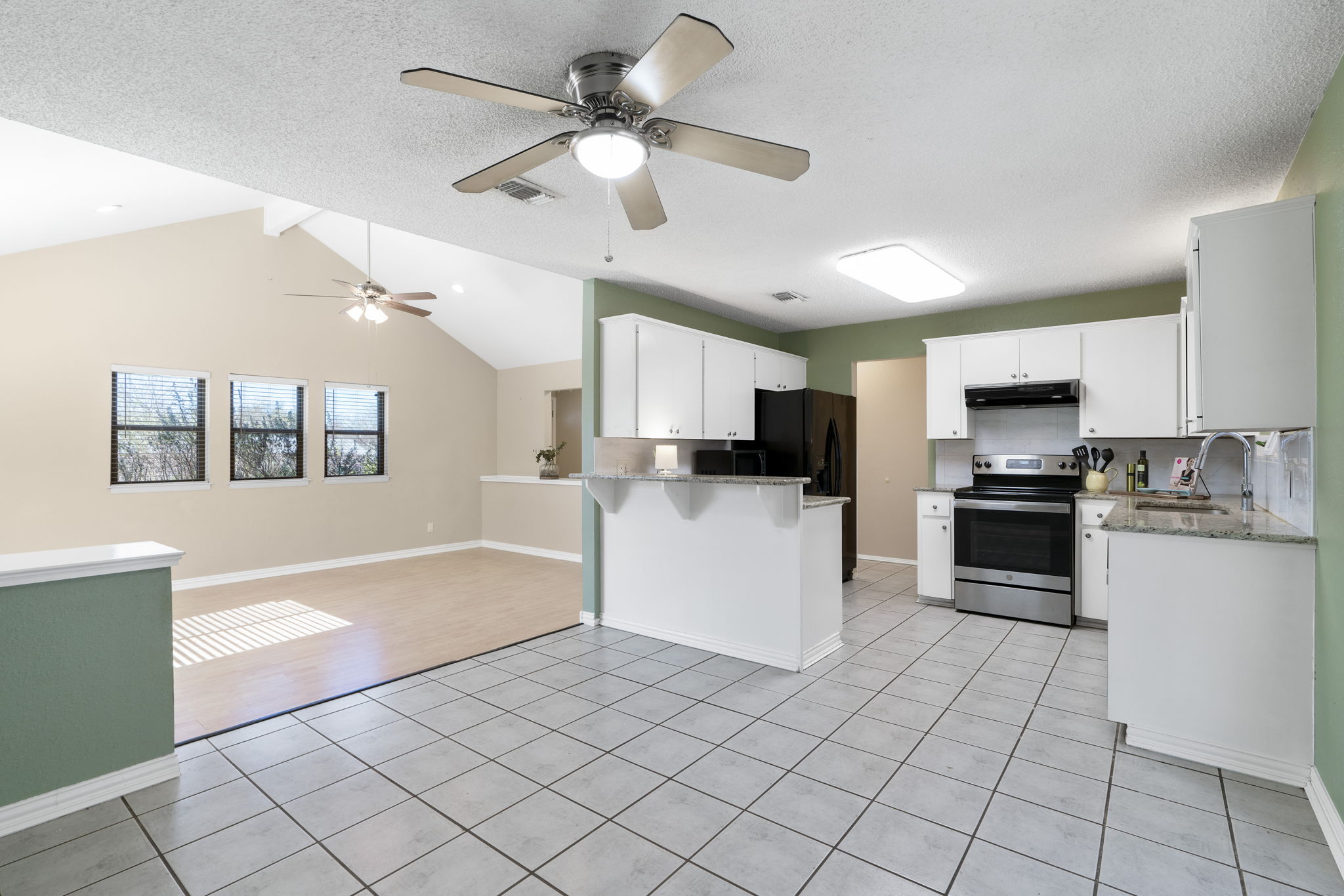 500 Grand Prairie Circle Dripping Springs, TX 78620 - Photo 40 of 40 a kitchen with granite countertop a refrigerator oven a sink dishwasher and white cabinets with wooden floor