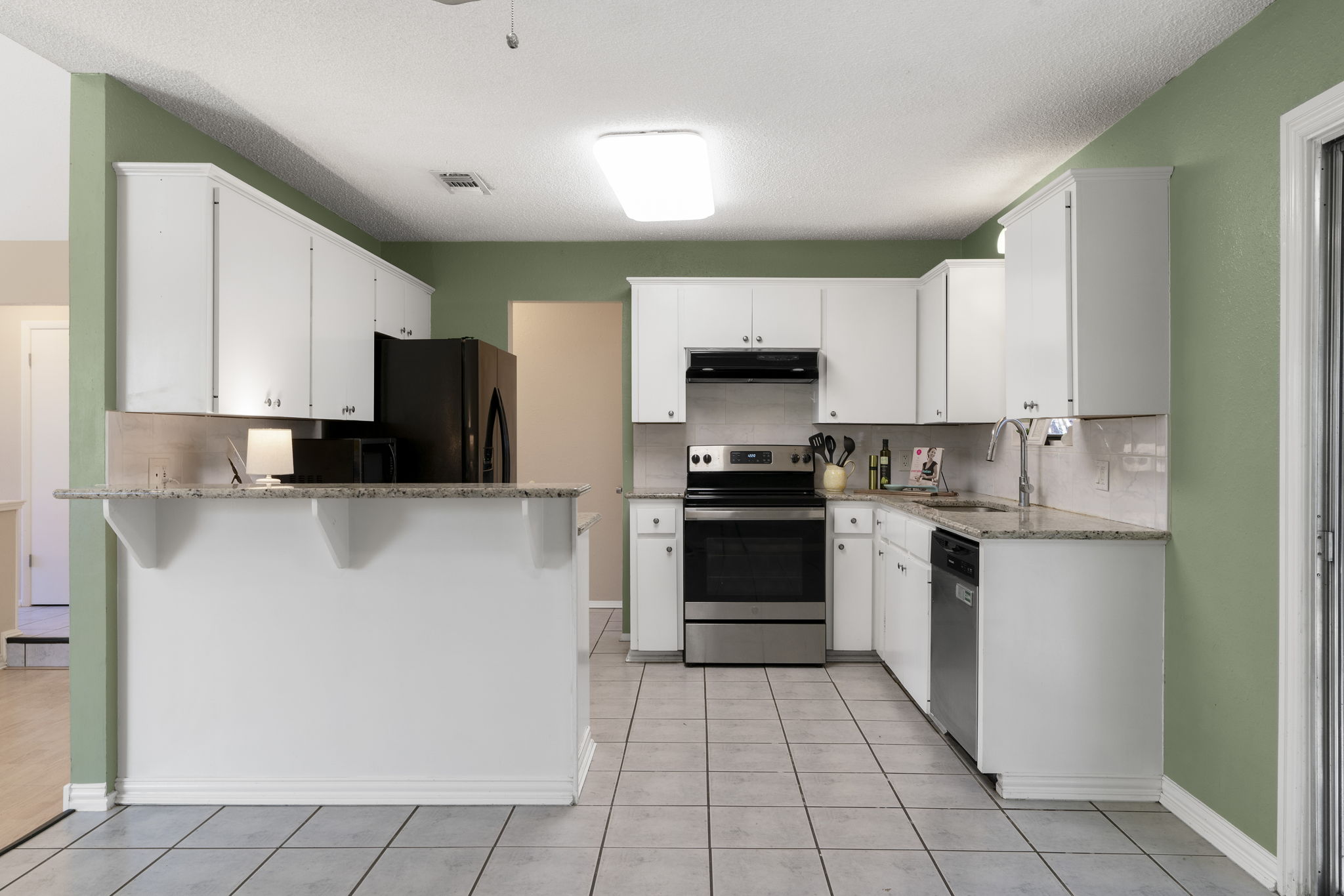 500 Grand Prairie Circle Dripping Springs, TX 78620 - Photo 12 of 40 a kitchen with granite countertop a refrigerator and a sink
