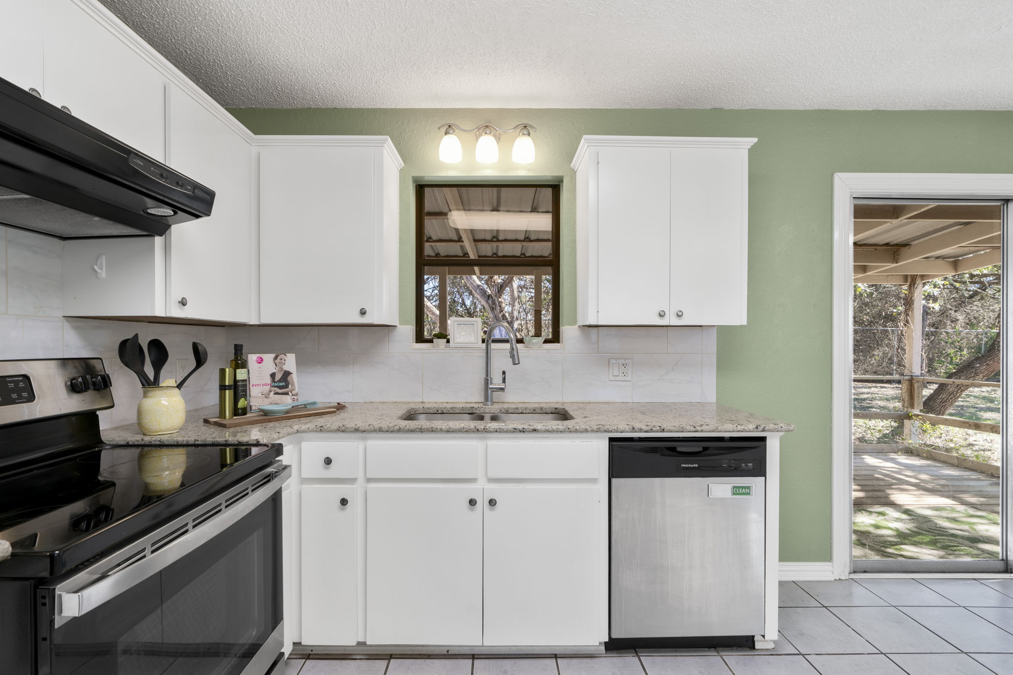 500 Grand Prairie Circle Dripping Springs, TX 78620 - Photo 14 of 40 Kitchen featuring stainless steel appliances, decorative backsplash, ventilation hood, white cabinets, and a textured ceiling