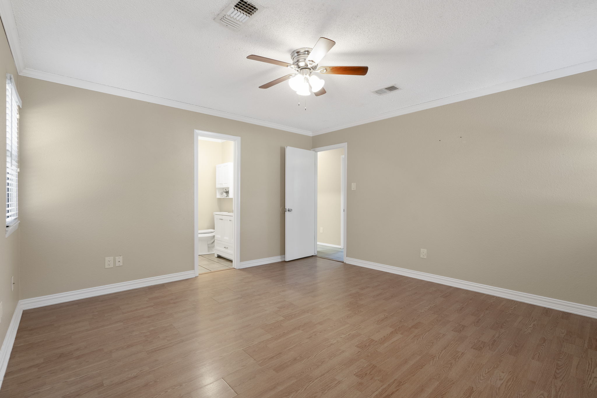 500 Grand Prairie Circle Dripping Springs, TX 78620 - Photo 18 of 40 Unfurnished bedroom with crown molding, light wood-type flooring, and ceiling fan