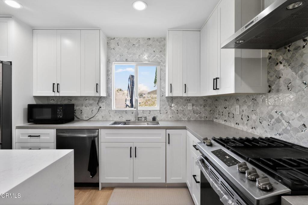 2377 Fitzgerald Road Simi Valley, CA 93065 - Photo 12 of 30 a kitchen with stainless steel appliances a sink dishwasher stove and white cabinets