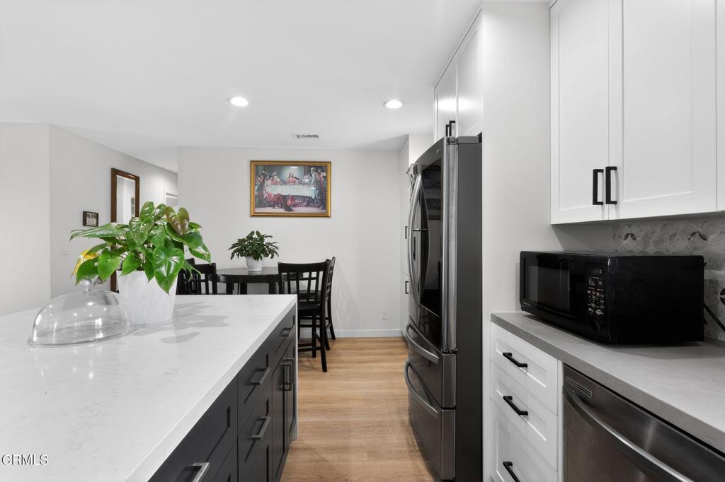 2377 Fitzgerald Road Simi Valley, CA 93065 - Photo 13 of 30 a kitchen with a potted plant on the counter and cabinets